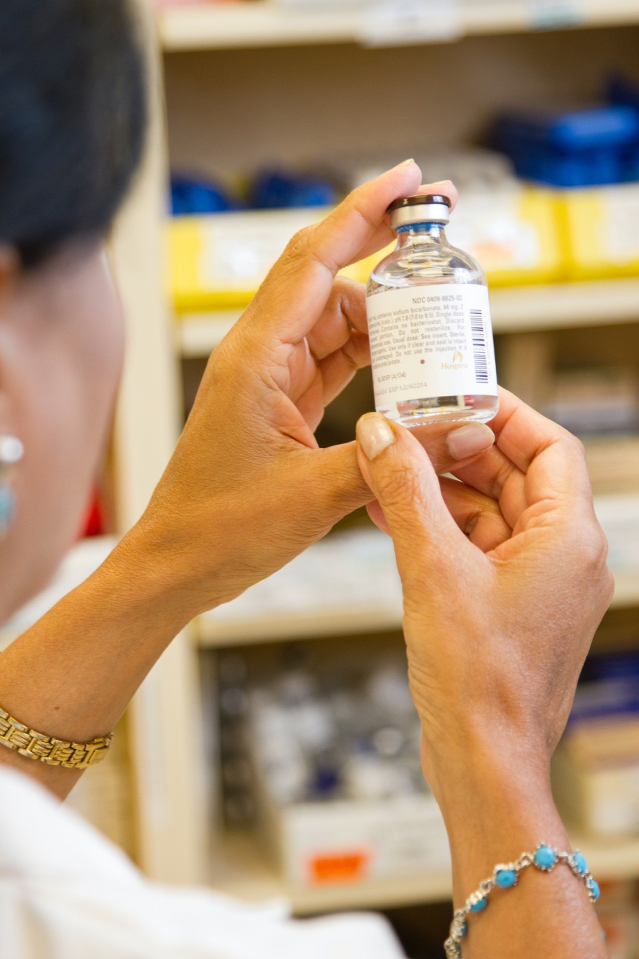 A pharmacy professional checking a medication label